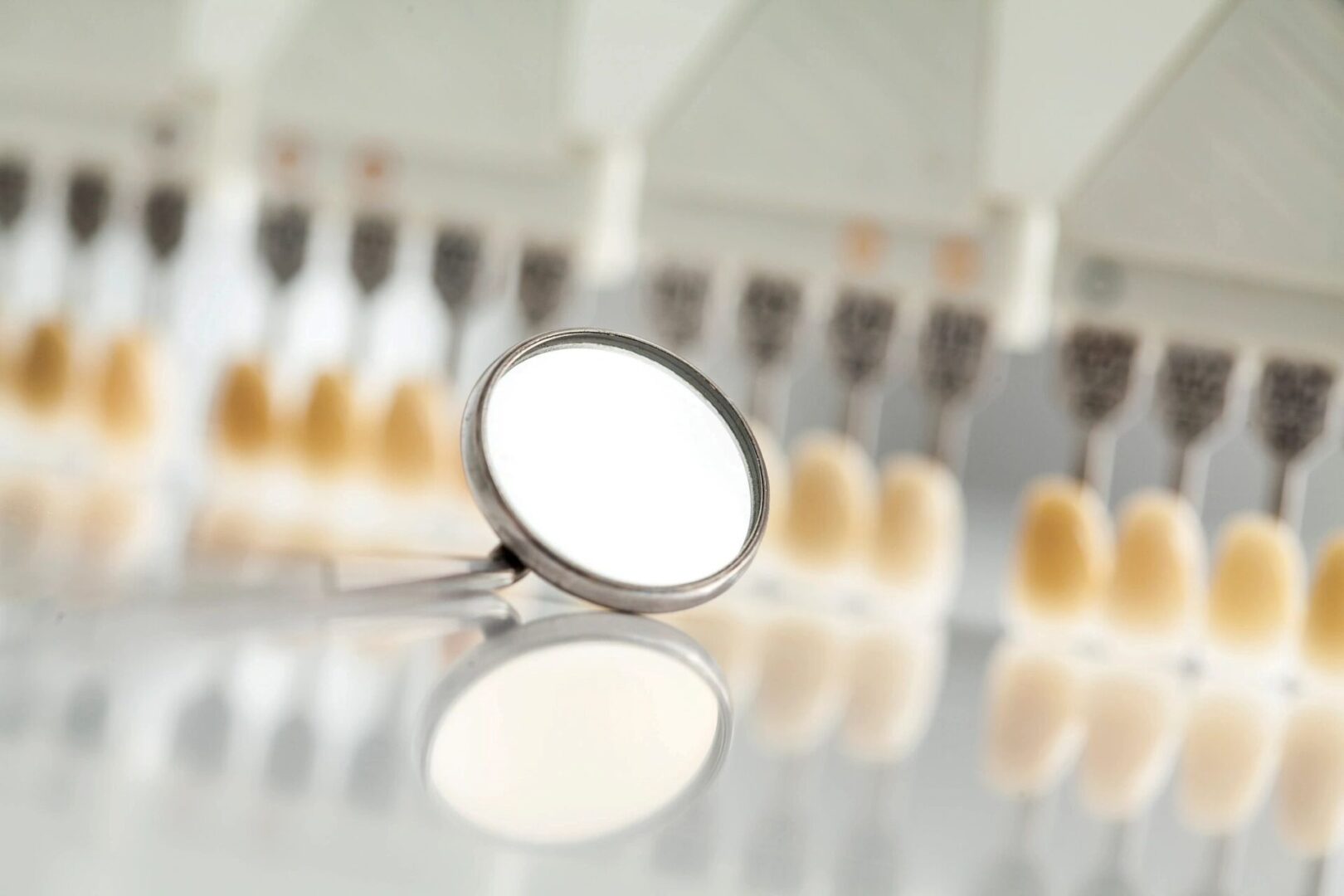 A mirror and some rows of teeth on the table